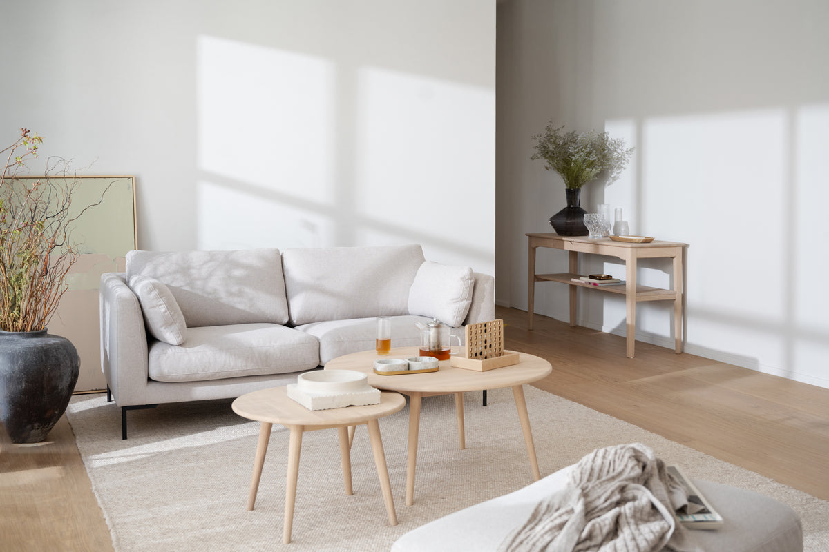 Corwin 2,5-sitssoffa i ljusbeige tyg med svarta metallben, Tompkins soffbord och Markham konsolbord i vardagsrum, miljöbild